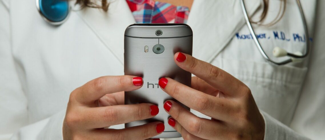 Telehealth doctor holding up a mobile device